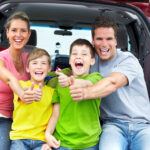 Smiling happy family and a family car